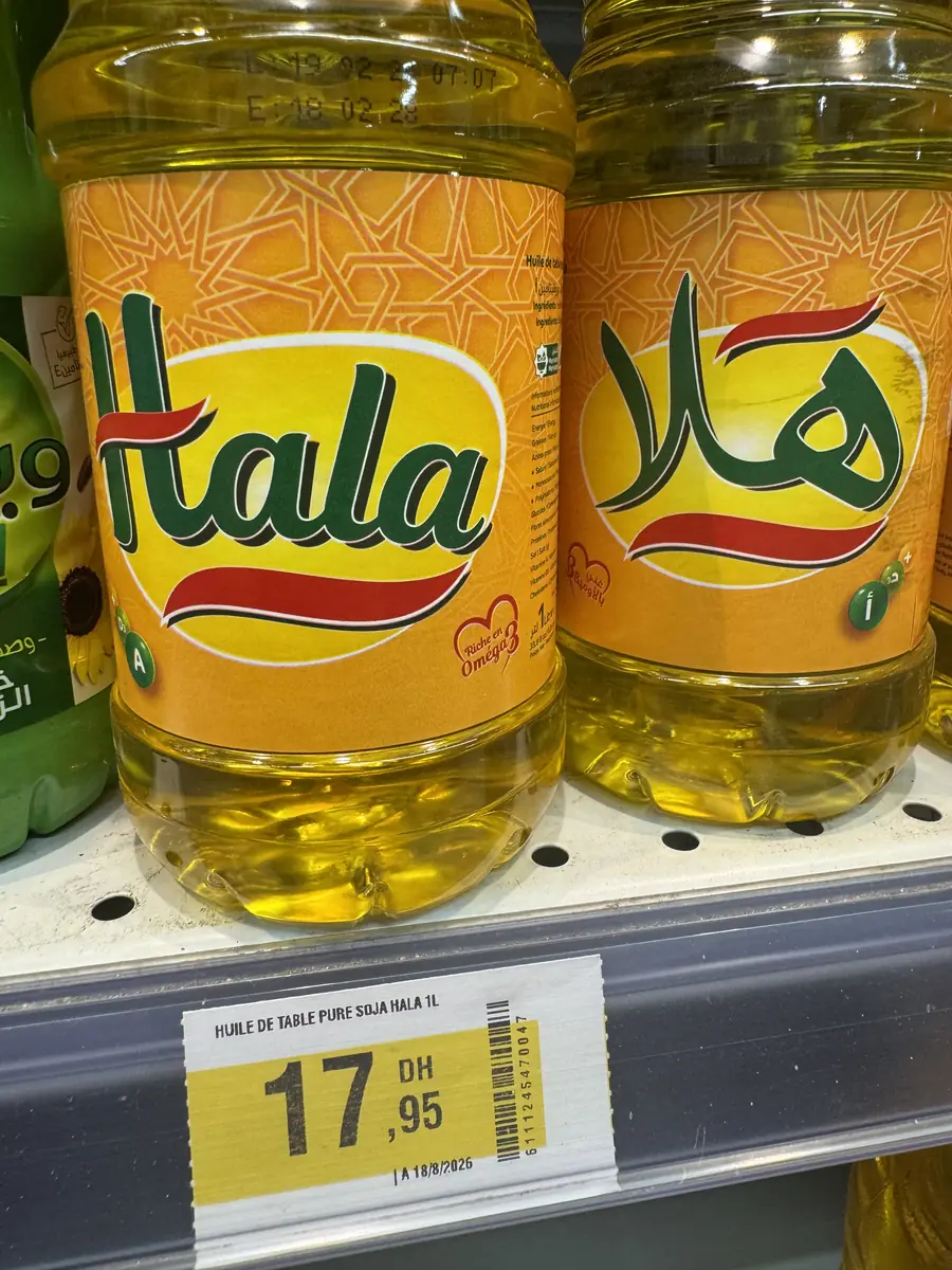 Бутылка масла Hala 1 л с ценником 17,95 дирхама на полке магазина в Марокко